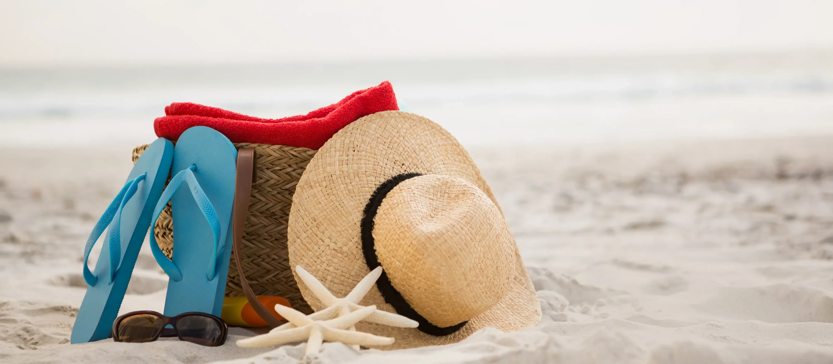 Bag and beach accessories kept on sand
